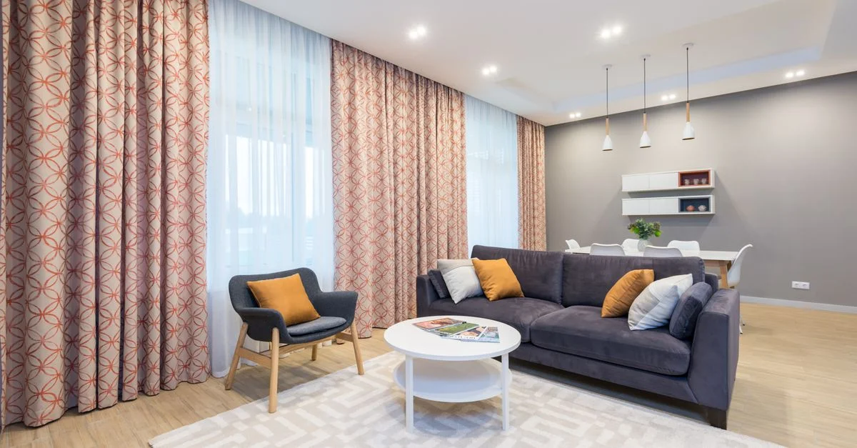 Salon spacieux moderne avec des meubles et une décoration élégants, accompagnés d'un éclairage d'accent chaleureux.