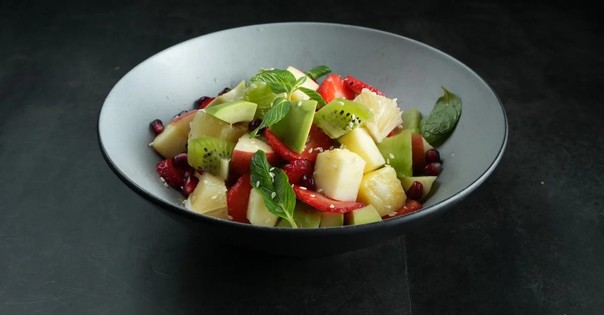 Une salade de fruits colorée et saine avec de la kiwi, de l'ananas et des fraises.