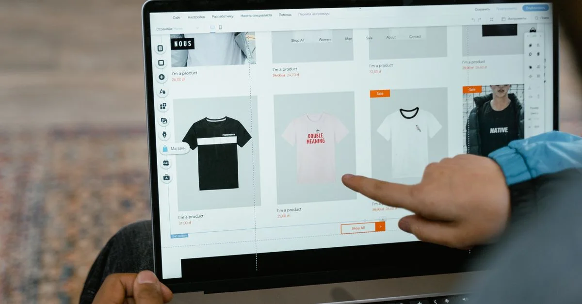 Une personne pointe des options de t-shirt dans une boutique en ligne sur l'écran d'un ordinateur portable.