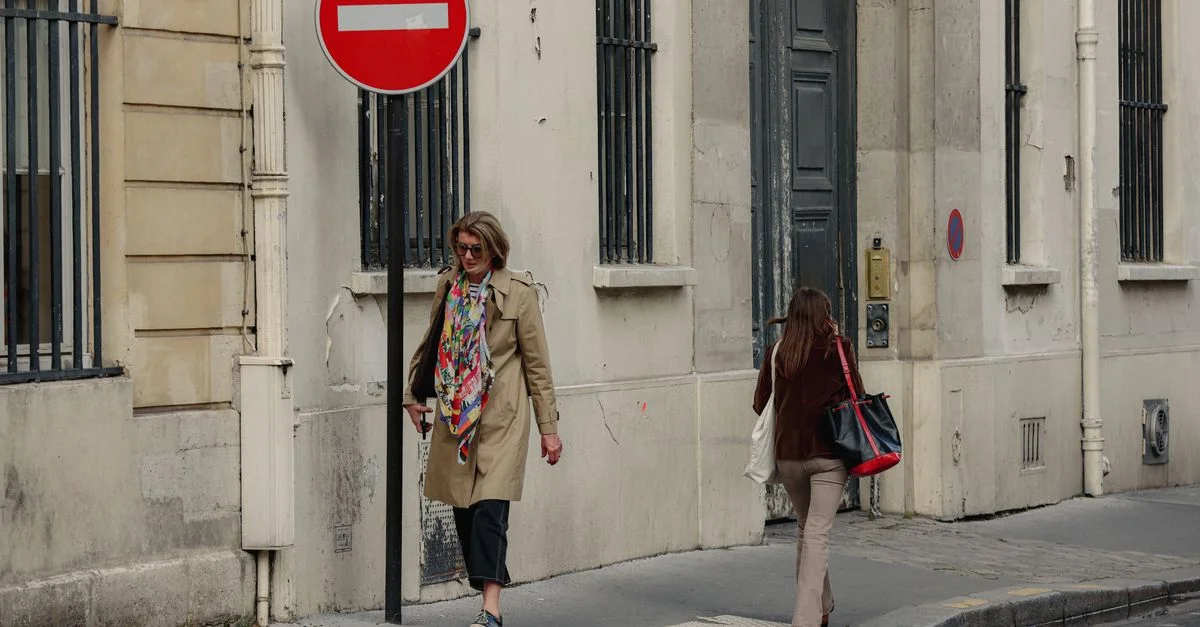 Scène urbaine à Paris, Île-de-France, avec deux femmes marchant et un panneau d'entrée interdite en vue.