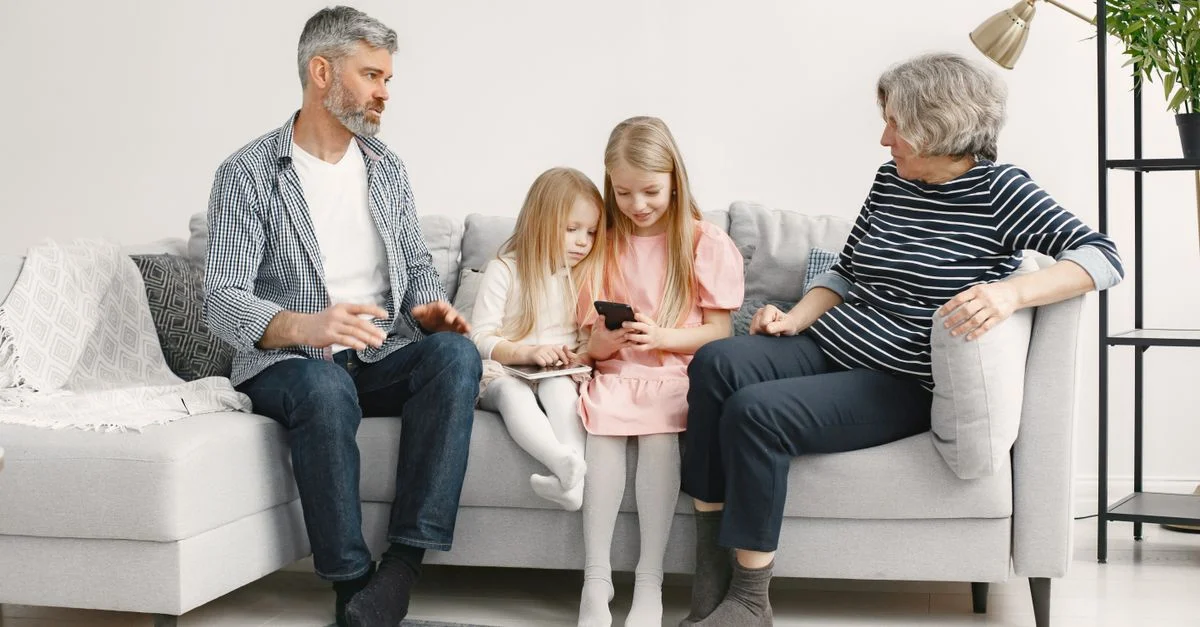 Une famille joyeuse profite de moments de qualité ensemble sur un canapé confortable dans le salon.